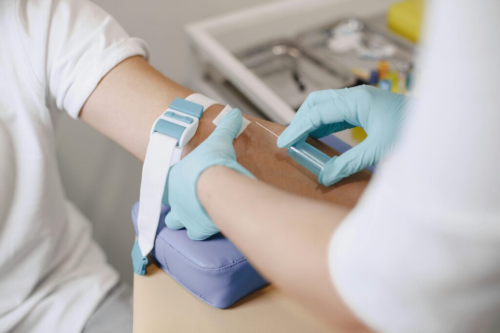 Close-up of a healthcare professional drawing blood from a patient in a medical setting.